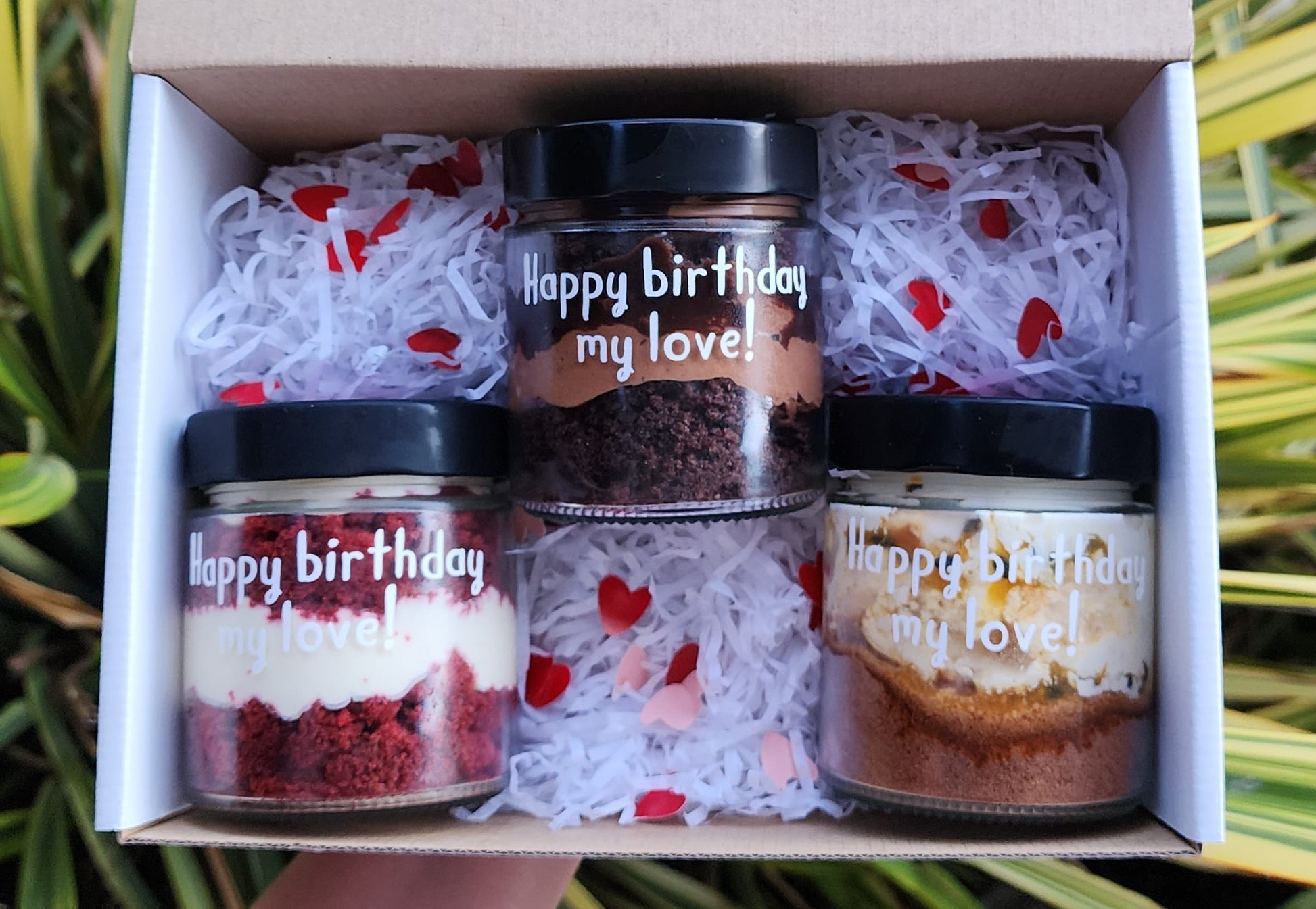 layers of cake and frosting in a jar with custom label saying happy birthday
